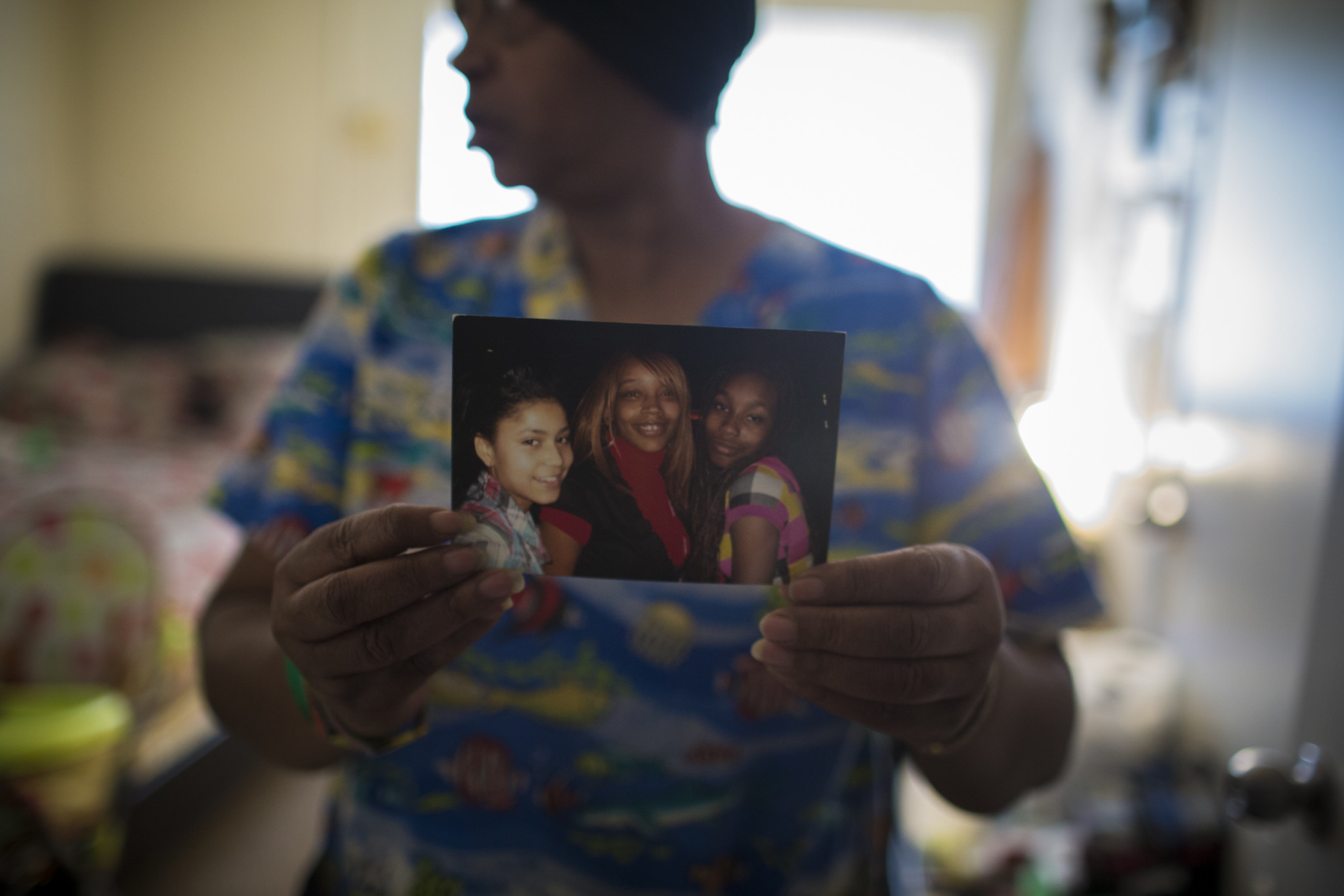 Tonya Kamara holds a photograph of her daughter April (in the middle), who is currently incarcerated at the Correctional Treatment Facility (CTF) in Washington, D.C., for drug-related offenses.